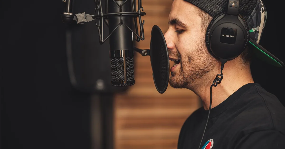 Musician records e-learning voice over services in a professional studio.