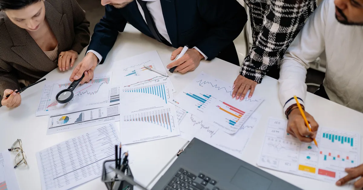 Professionals analyze charts, illustrating internationalization vs. localization in finance.