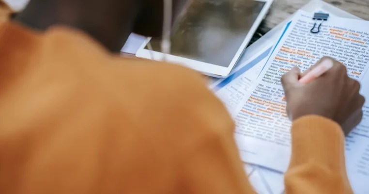 Anonymous person outlining text at tablet, considering light and full post-editing.