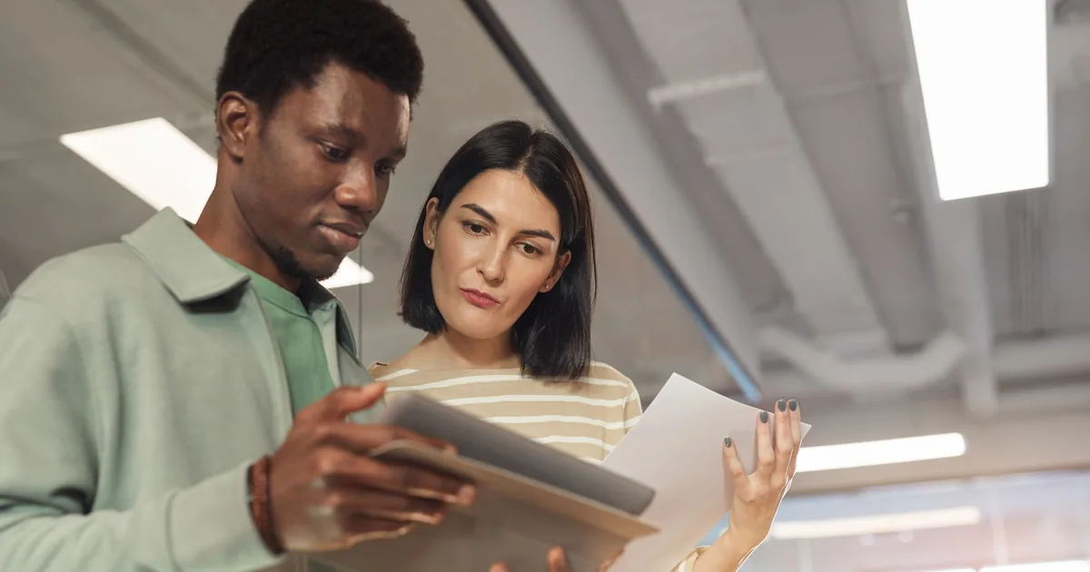 Professionals collaborate on a tablet, discussing light and full post-editing needs.