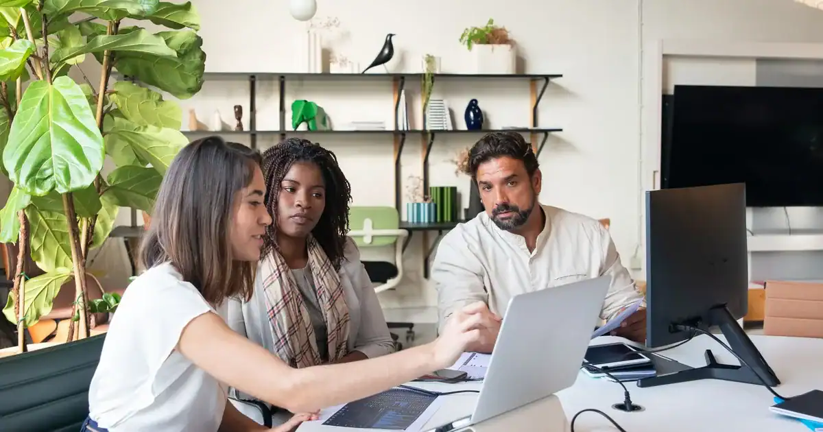 Professionals collaborate on laptops, developing a multilingual SEO strategy.