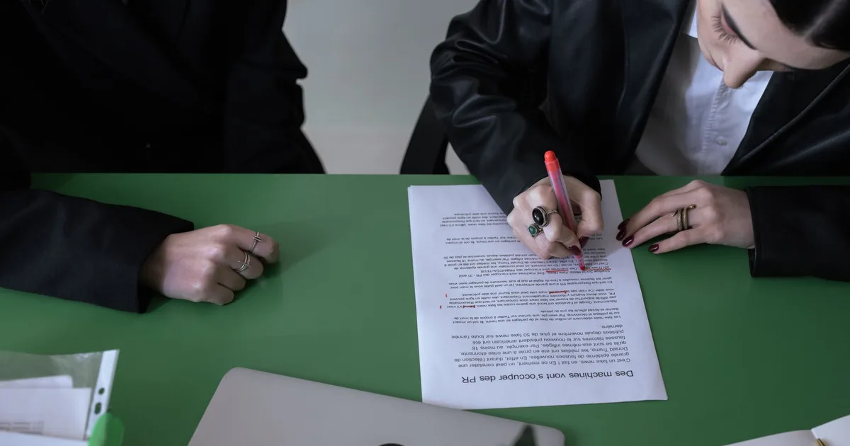 Woman edits document with red pen, a Übersetzungsbüro mit MTPE.