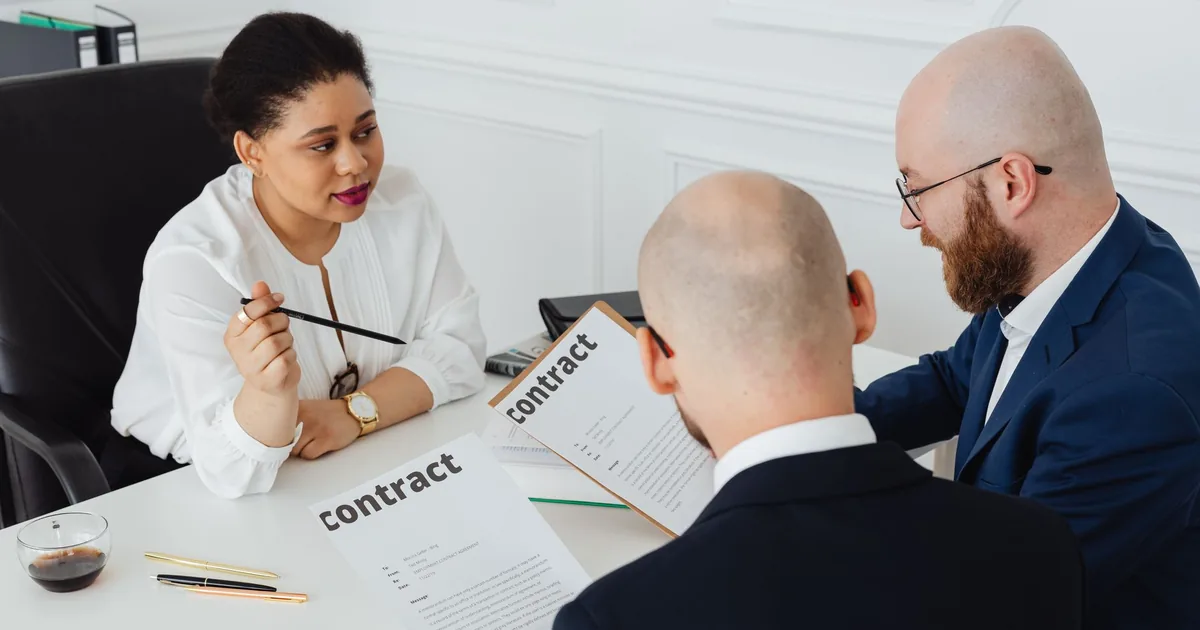 Professionals discuss a contract, weighing the benefits of an Übersetzungsbüro vs. Freelancer.