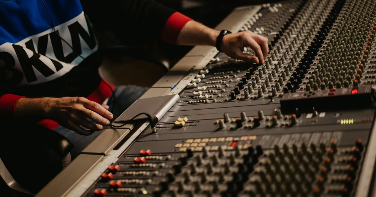 Sound engineer fine-tuning audio levels for dubbing vs voice over.