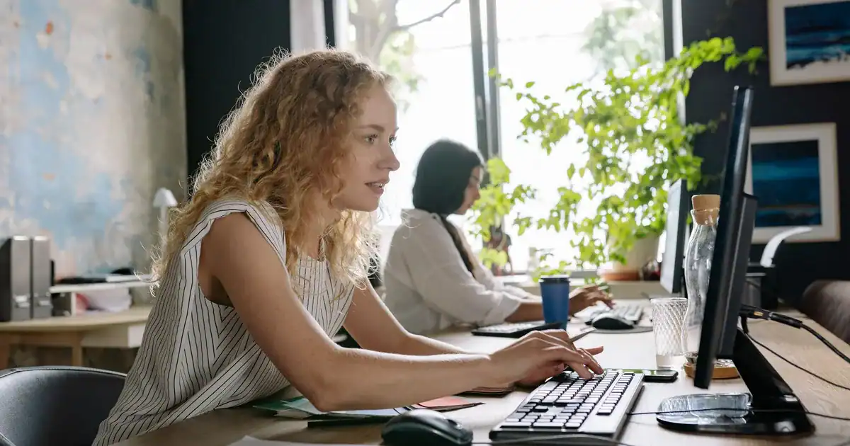 Two women at a modern desk performing what is MTPE for professional language services.