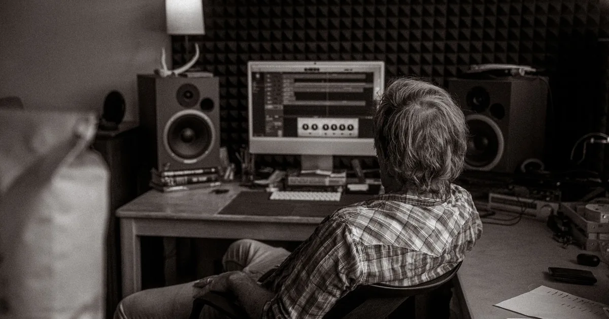 Man in studio editing audio, a realistic take on AI vs human voice over.