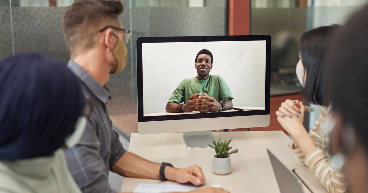 A diverse group having a video conference meeting in an office setting, promoting teamwork and colla
