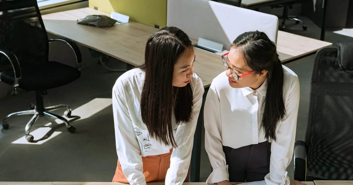 Two women review documents, symbolizing our global localization company's collaborative approach.