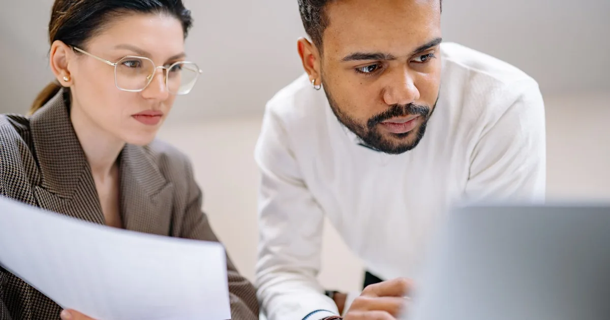 Colleagues analyzing documents: how to choose MTPE provider teamwork.