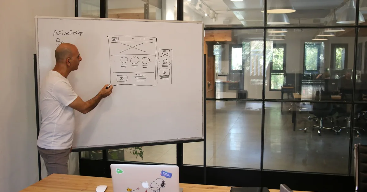 Manager explains multilingual URL structure on whiteboard.