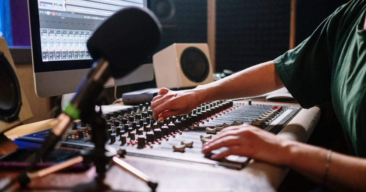 Professional audio engineer adjusting mixer in a modern sound studio. - FAS Localize