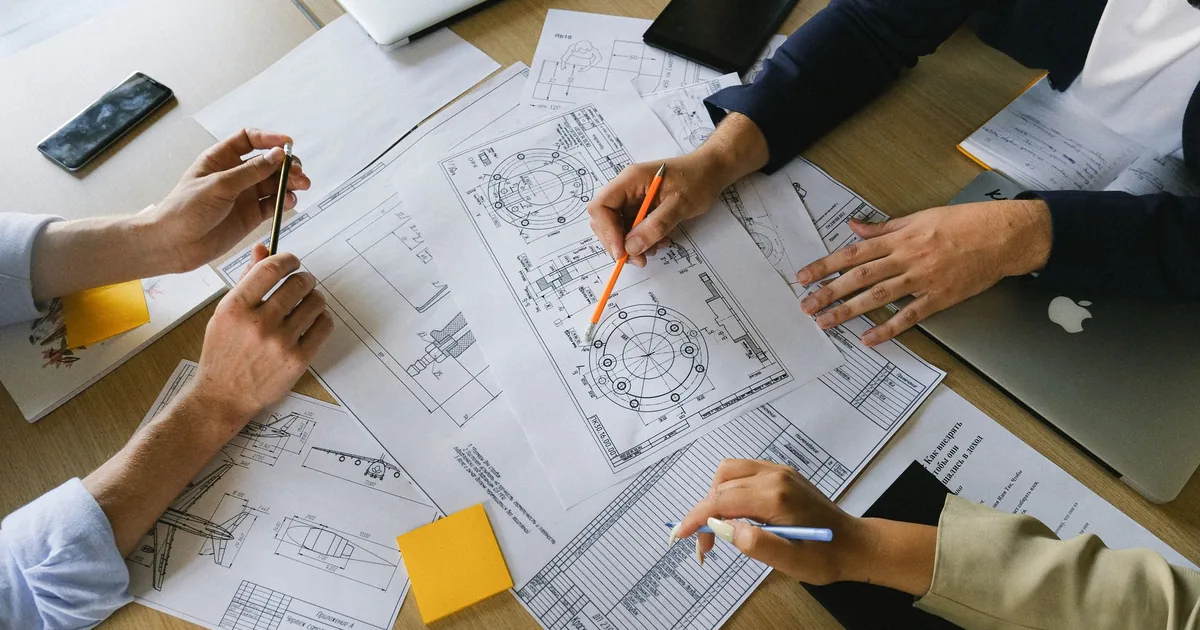 Colleagues discuss schematics, a part of technical translation services.