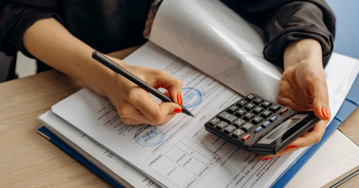 Accountant analyzes beglaubigte Übersetzung Vietnamese costs with calculator & papers.